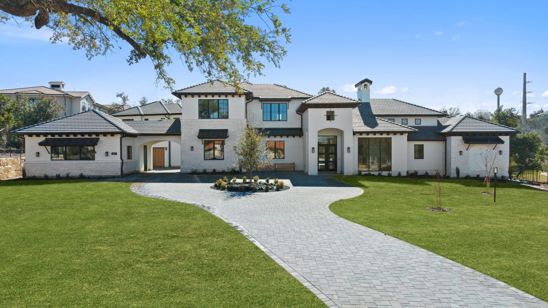 Elegant two-story house with a curved driveway and landscaped front yard.