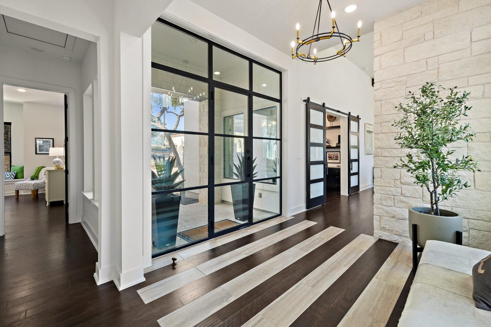 Modern entryway with glass doors and striped flooring.