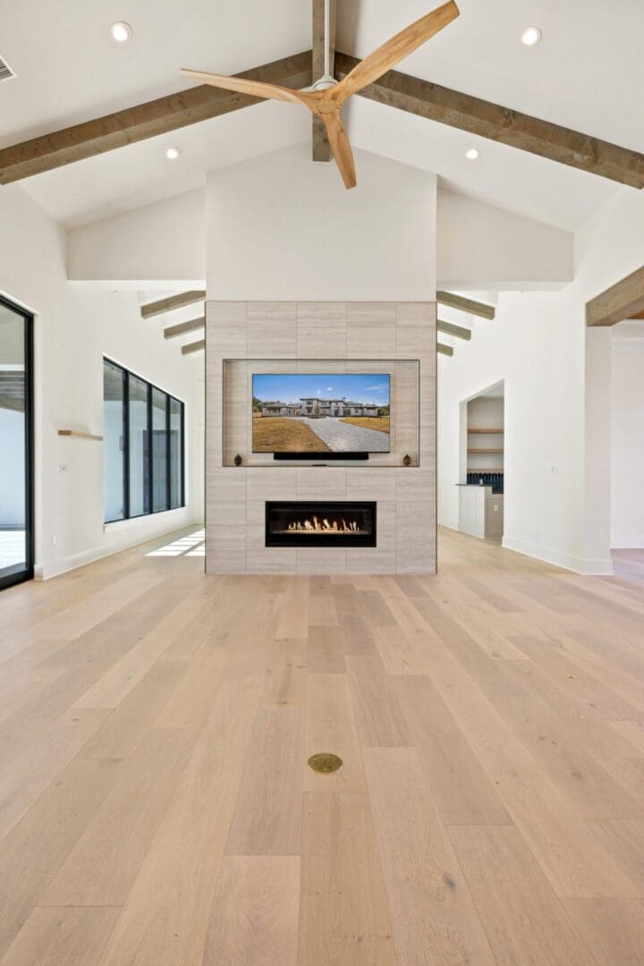Modern open living space with fireplace and large windows.