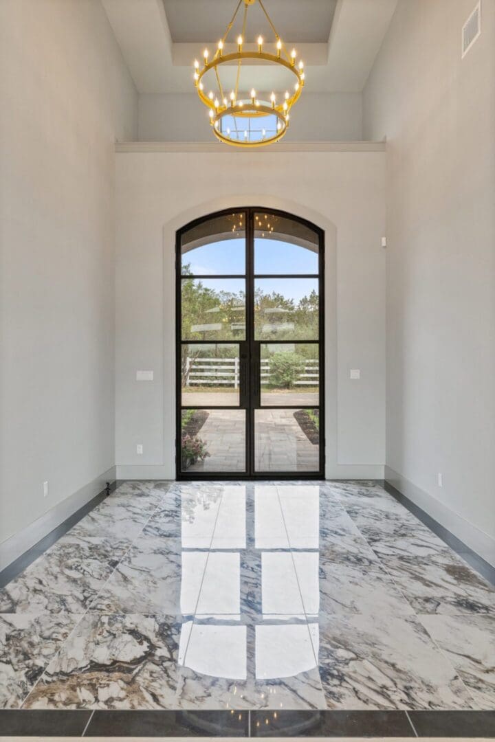 Bright entryway with glass door and polished marble floor.