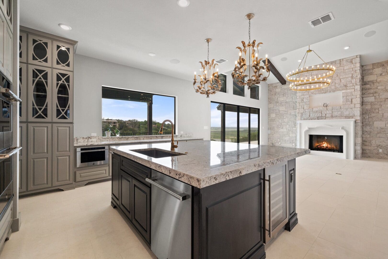 Modern kitchen with dark island and large windows.