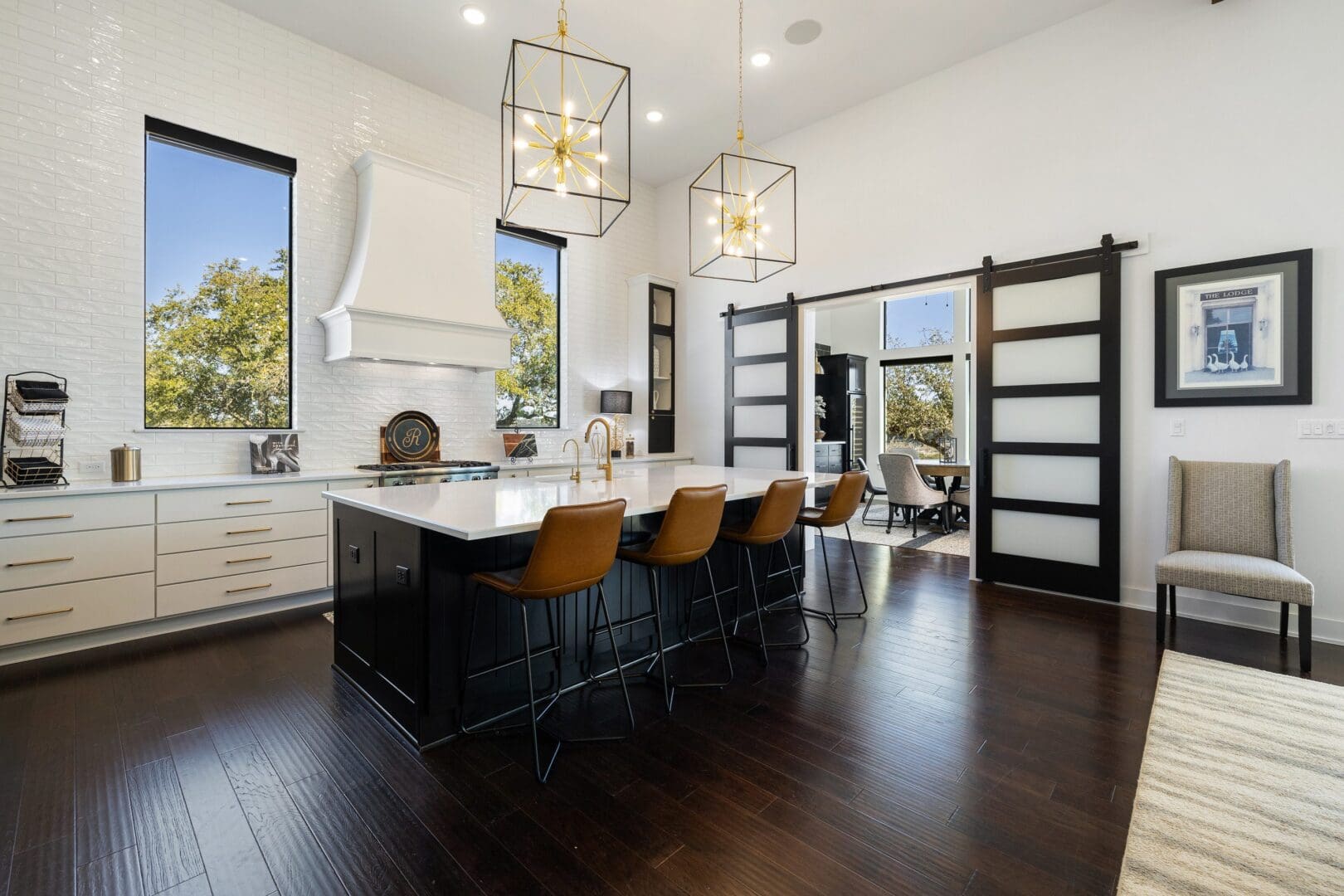 Modern kitchen with large island and stylish pendant lights.