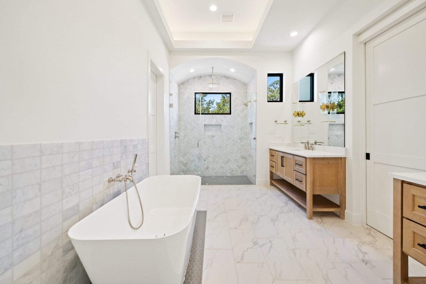 Bright modern bathroom with freestanding bathtub and double vanity.