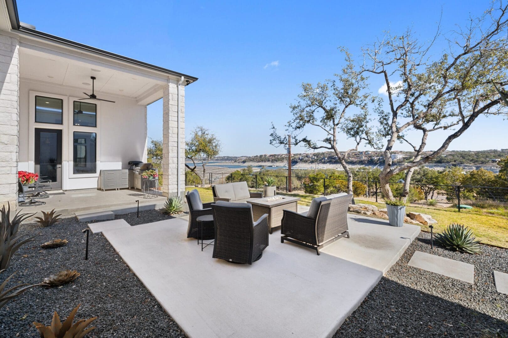 Modern outdoor patio with wicker chairs and scenic view.