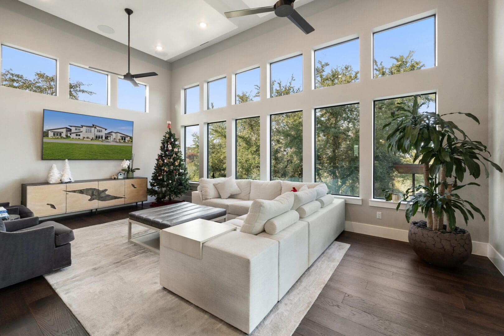 Bright modern living room with large windows and a white sectional sofa.