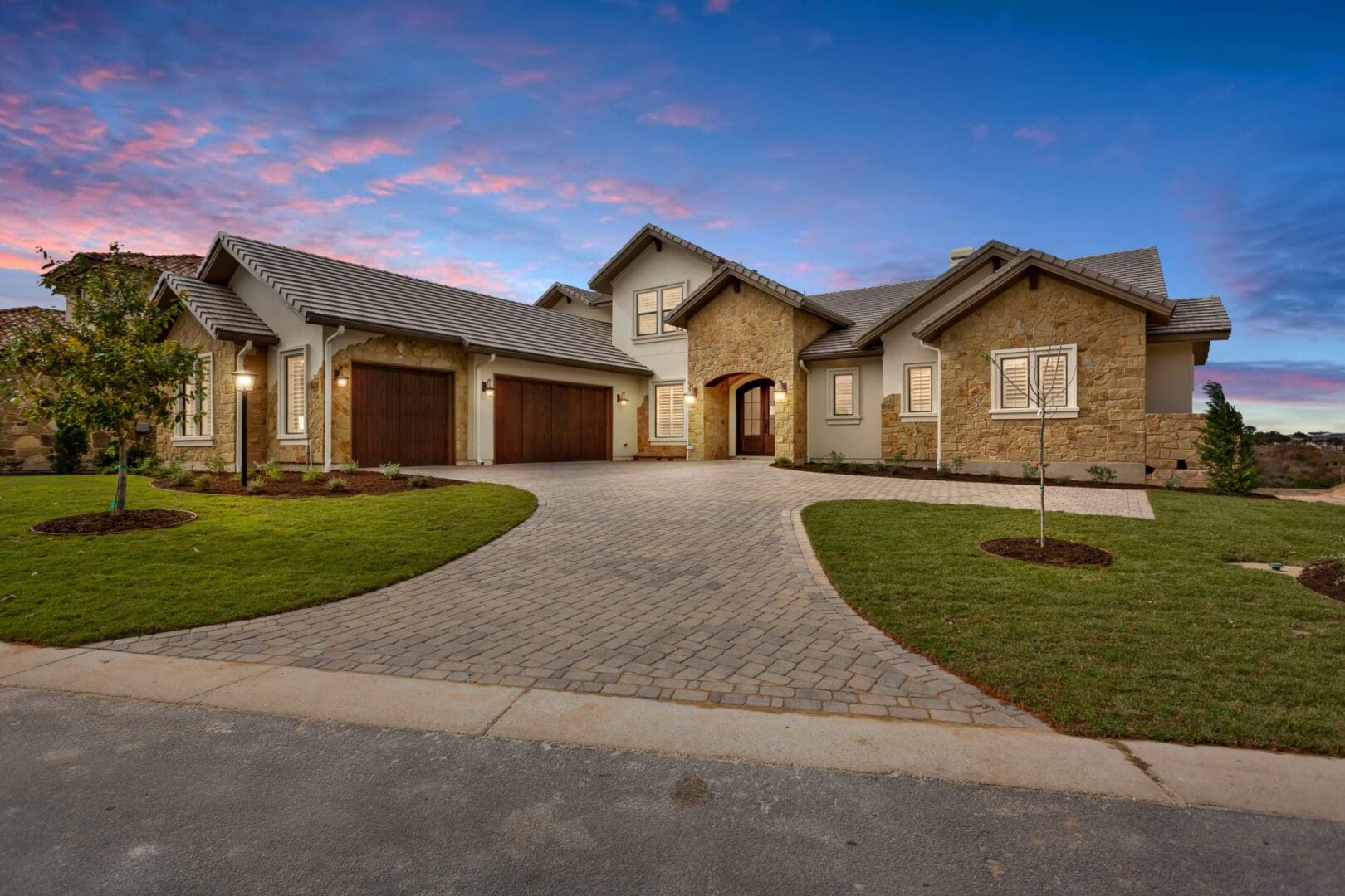 Modern house with stone and brick exterior during sunset.