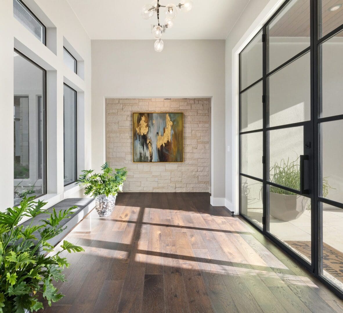 Bright modern hallway with glass walls and wooden floor.