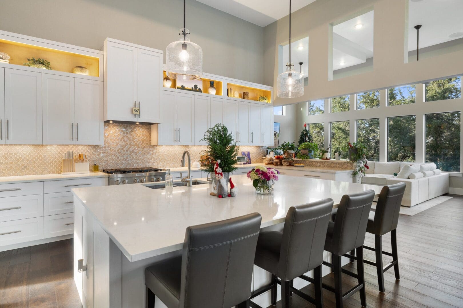 Modern kitchen with large island and bar stools under bright lighting.