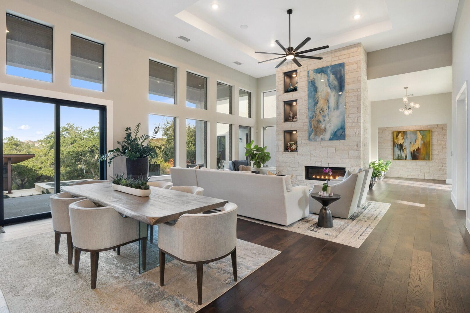 Modern living and dining area with neutral tones and large windows.