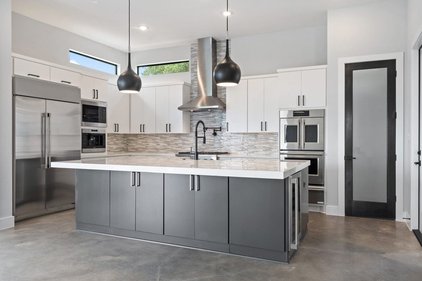 Modern kitchen with gray island and white cabinetry.