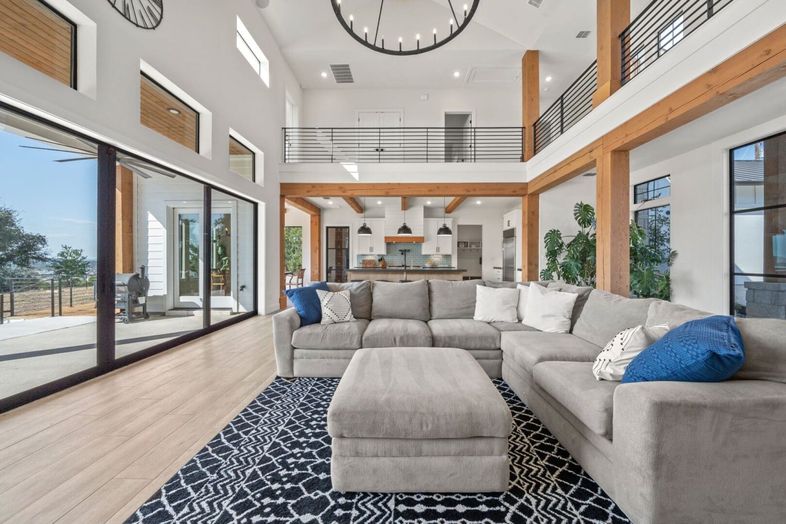 Spacious modern living room with double-height ceilings and a cozy sectional sofa.