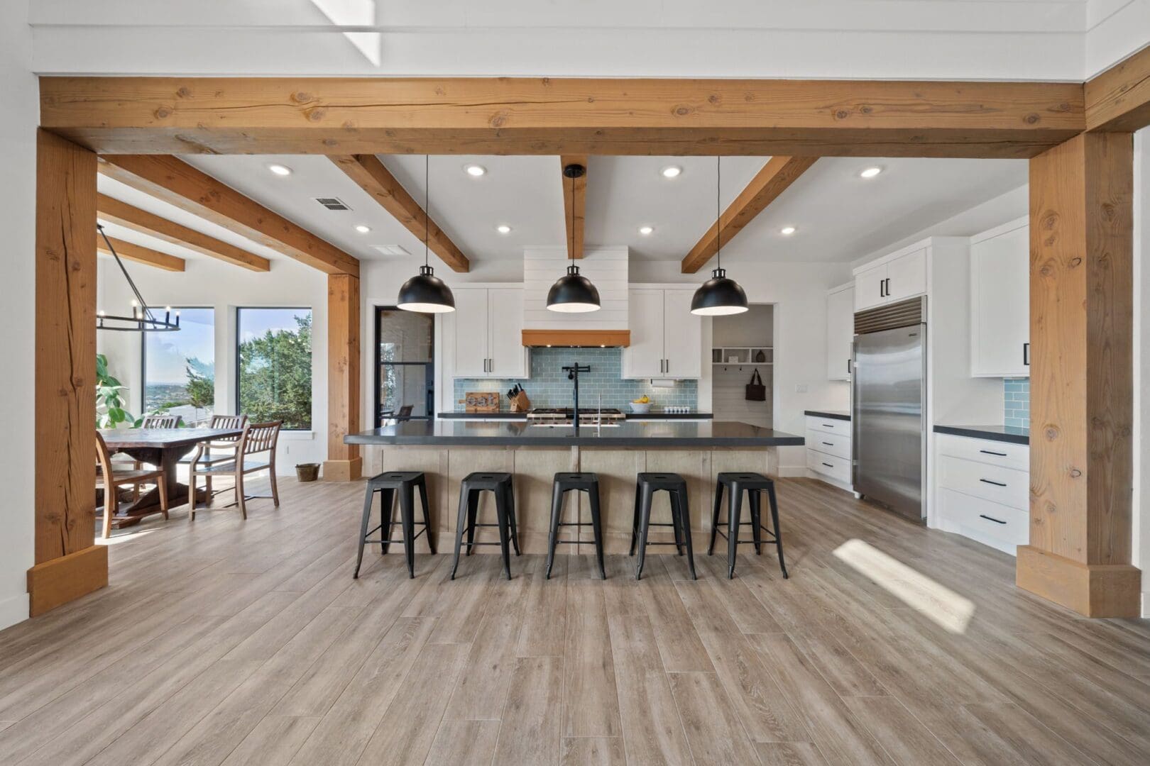 Modern kitchen with wooden beams and bar stools.