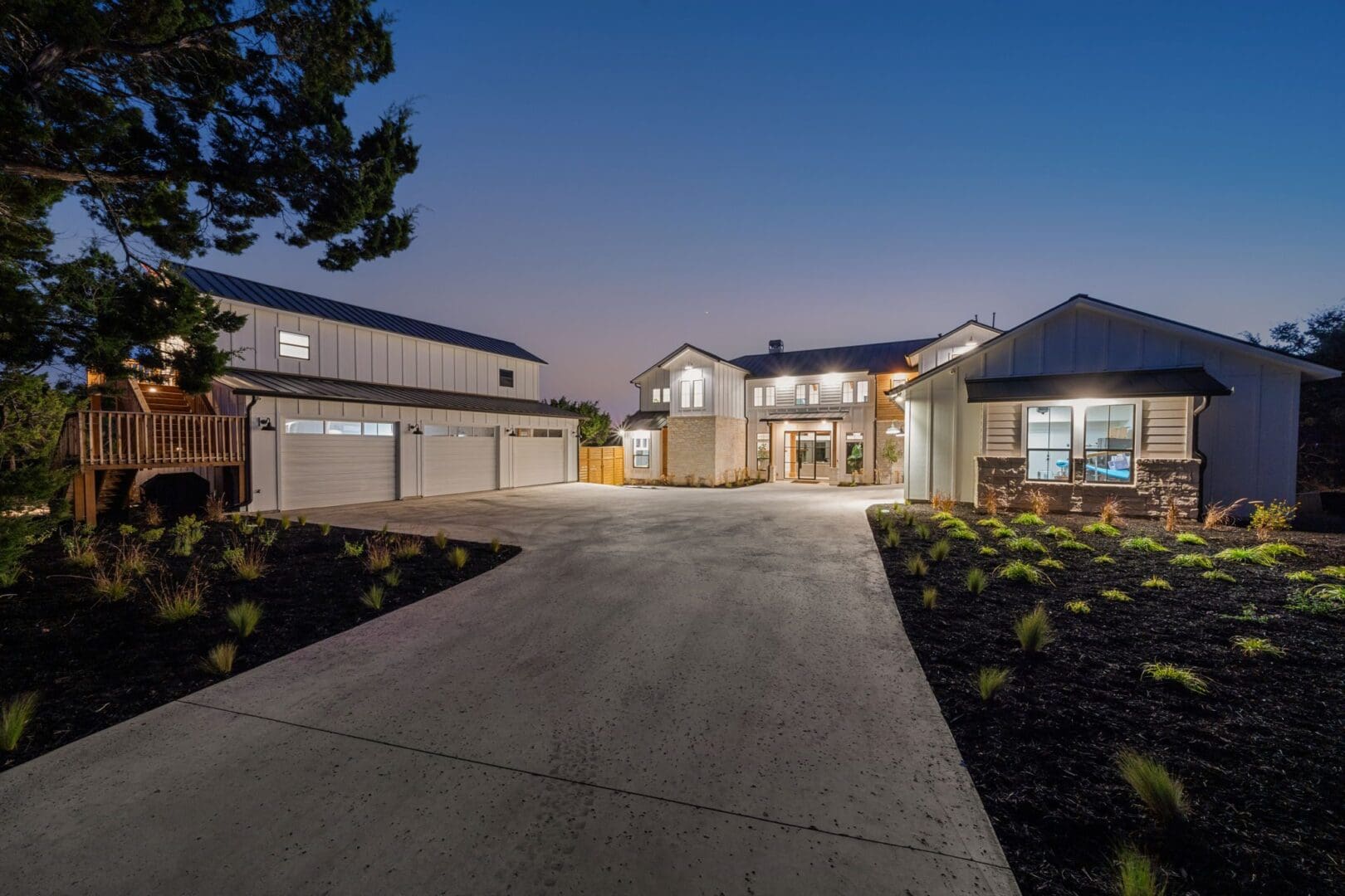 Modern house with illuminated driveway at twilight.