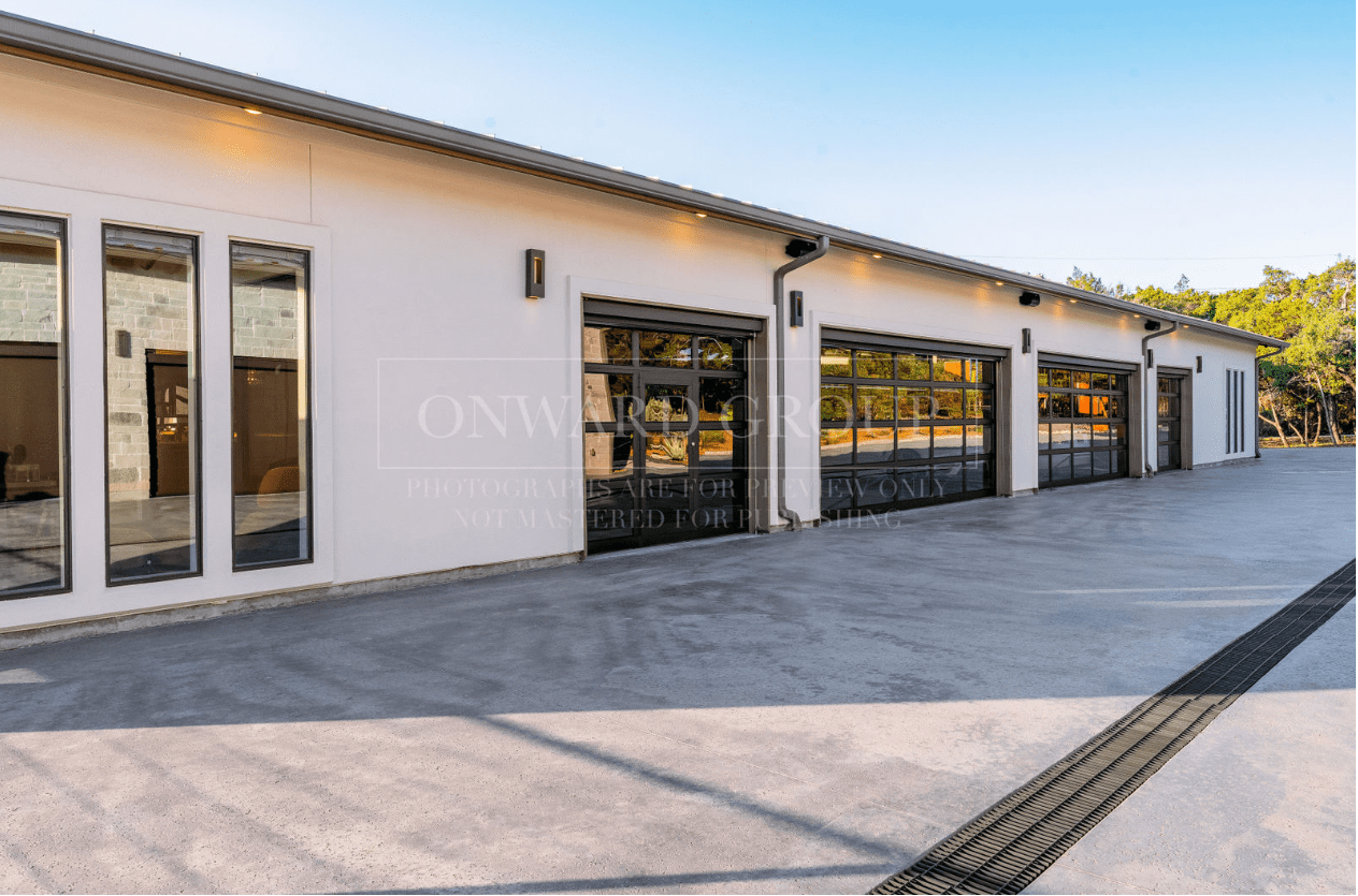 Modern industrial building with large garage doors and concrete driveway.