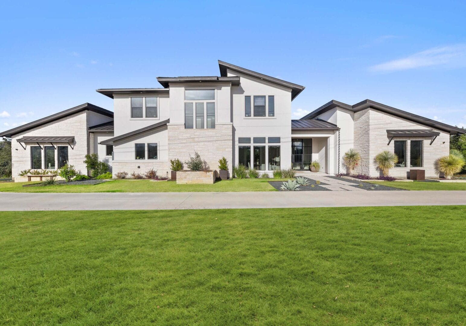 Modern house with large windows and lawn.